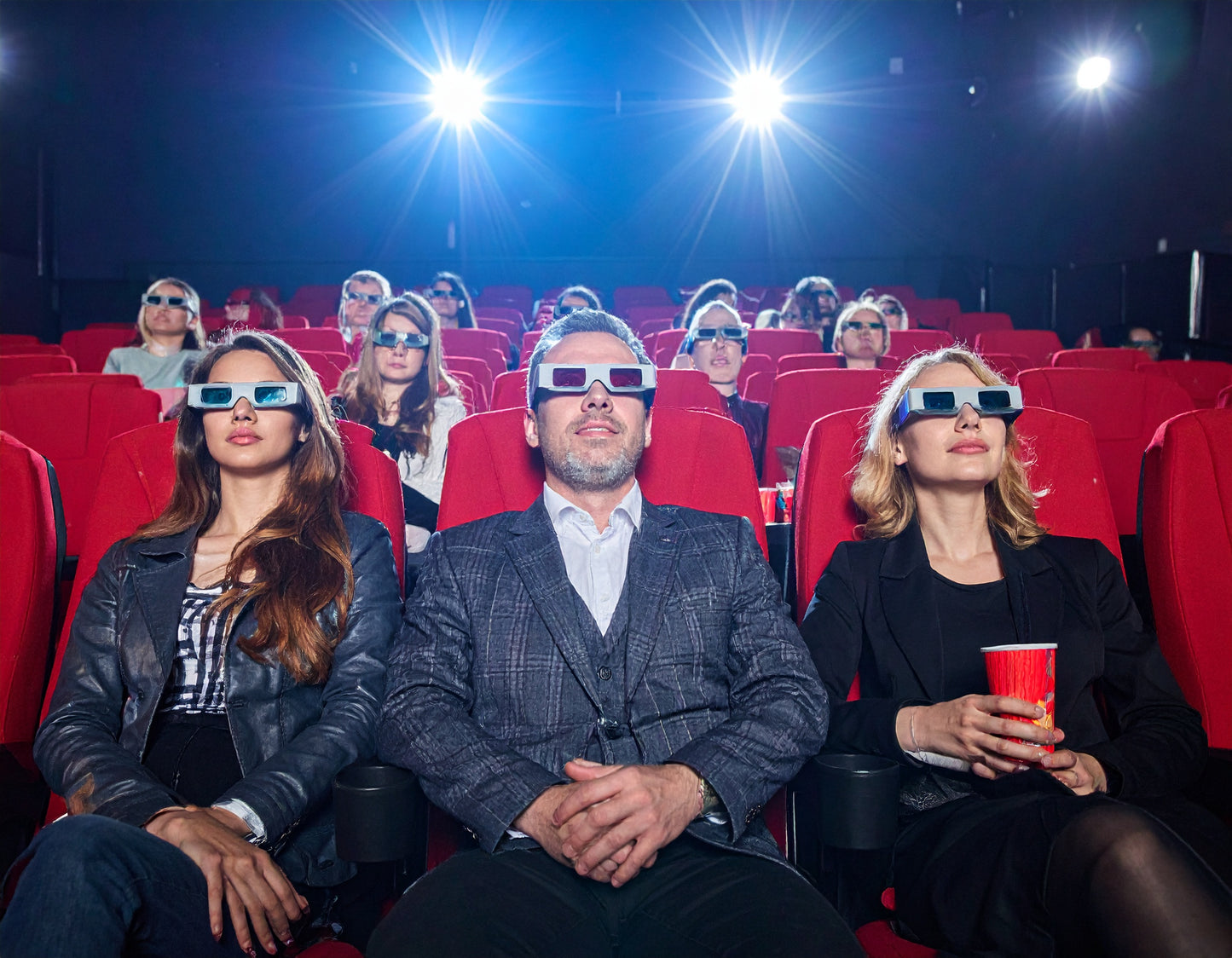 People in a movie theater wearing 3D glasses.