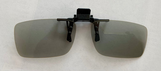 Gray 3d glasses with a black clip on a light gray background