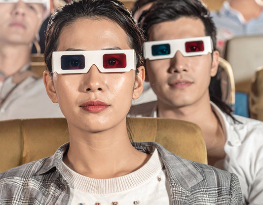 People wearing 3D glasses in a movie theater setting