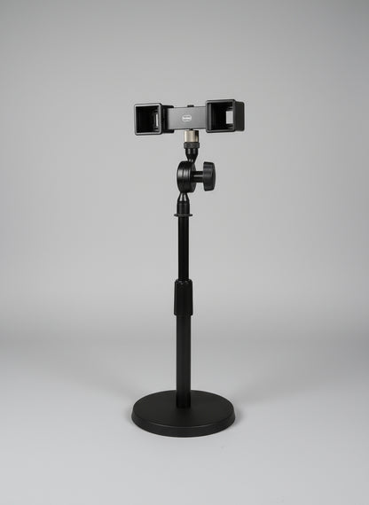 Camera stabilizer attached to a chair with a window and curtain in the background