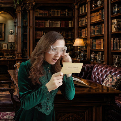 A woman in a dark green velvet dress wearing clear magnifying glasses holds a small card in a grand, dimly lit library with wooden bookshelves and leather seating.